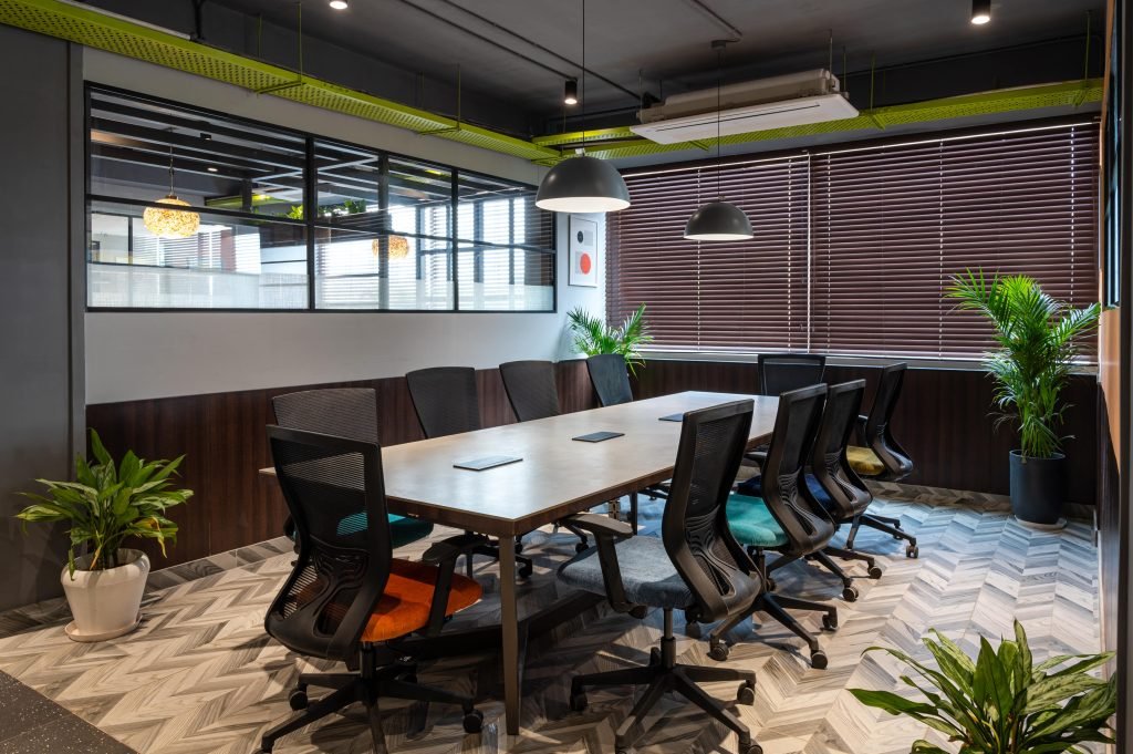 Contemporary office conference room featuring nature-inspired aesthetics, wooden furniture, indoor plants, and natural lighting.